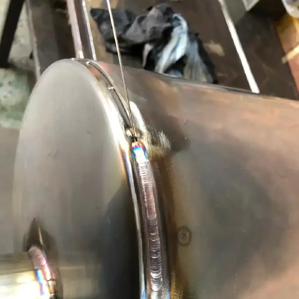 Welded muffler end cap
