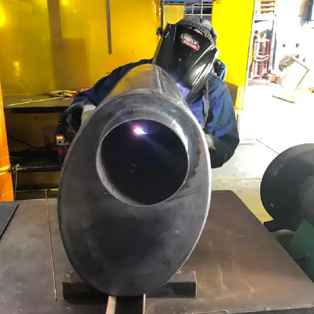 Welder fabricating an oval muffler